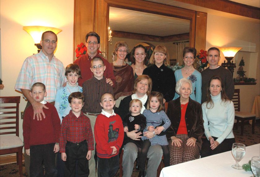 Mark (L) in a Christmas photo a few years ago. Liz is seated, center, holding their two daughters. TOC in black velvet shirt.